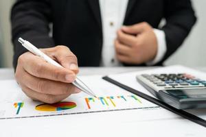 contador asiático trabalhando e analisando contabilidade de projeto de relatórios financeiros com gráfico gráfico e calculadora no conceito moderno de escritório, finanças e negócios. foto