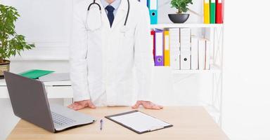 retrato do médico sênior no consultório médico. homem de uniforme branco foto