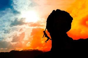 alpinista solitário quase no topo da montanha ao pôr do sol com um foto