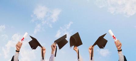 pessoas que tiveram sucesso na educação segurando um chapéu de formatura no fundo de um céu brilhante com beleza foto