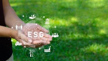 jovens profissionais prontos para usar a tecnologia de recursos renováveis da esg para reduzir a poluição no conceito de esg ícone nas mãos do meio ambiente, da sociedade e da governança empresarial sustentável. foto