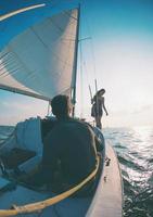 um homem e uma mulher estão viajando em um iate à vela. foto