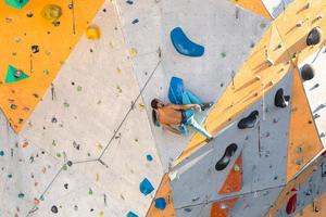 um homem está escalando uma parede de escalada foto