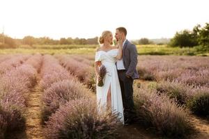 noiva e noivo no campo de lavanda foto