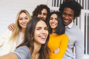 grupo multiétnico de amigos tirando uma selfie juntos enquanto se divertem ao ar livre.