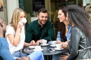 grupo multirracial de cinco amigos tomando um café juntos foto