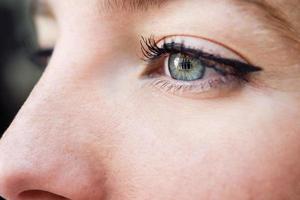 close-up do olho azul de uma jovem foto