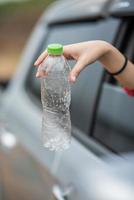 segurando uma garrafa de água e saindo do carro. foto