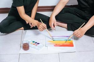 casais femininos desenham e pintam no papel. foto