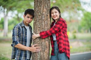 homens e mulheres em pé e abraçando árvores. foto