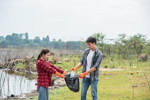 homens e mulheres ajudam uns aos outros a recolher o lixo. foto