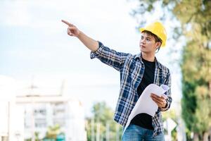 arquitetos seguram a planta do prédio e verificam a obra. foto