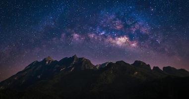 visão noturna da montanha natural com o espaço do universo da Via Láctea galáxia e estrelas no céu foto