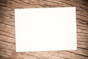 papel branco sobre fundo de madeira rústico simulado papel fotográfico na mesa ferramentas de arte folha branca uma mesa de madeira para texto foto