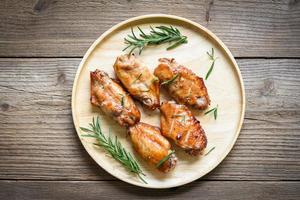 Asas de frango assado com molho e ervas e temperos cozinhar comida tailandesa asiática frango com alecrim grelhado foto