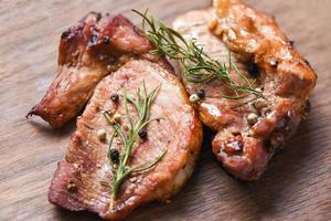 Carne de porco grelhada com molho e ervas e especiarias cozinhando comida asiática tailandesa carne de porco com alecrim na tábua de cortar foto