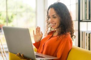 mulher latina trabalhando com laptop no sofá foto