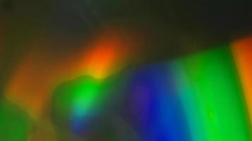 textura de refração de sobreposição de luz azul, amarela e verde colorida diagonal holográfica natural no preto. foto