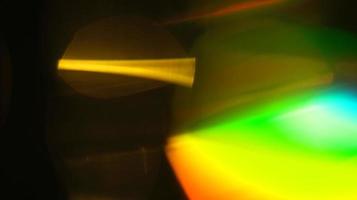 textura de refração de sobreposição de luz amarela do arco-íris holográfico natural diagonal no preto. foto