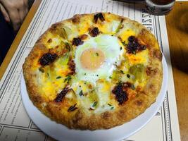 pizza saboroso queijo amarelo quente calabresa coberto fatias metade ovo cozido tomate com presunto e especiarias. foto