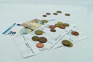 notas de euro, moedas de euro e recibos isolados no fundo branco. despesas e conceito de dinheiro foto