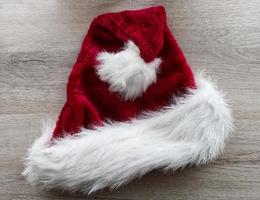 chapéu de Papai Noel isolado em fundo de madeira. conceito de feliz natal e feliz ano novo foto