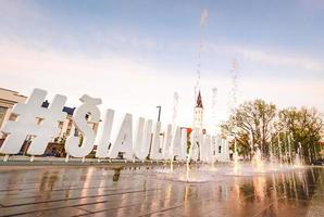 siauliai, lituânia - 27 de maio de 2021. novo monumento de siauliai da cidade do sol com bela catedral e fonte foto