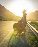ciclista na beira da estrada com raios de sol foto