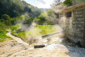 perto de fontes termais fumegantes em um dia ensolarado de verão na pitoresca paisagem da Geórgia ao fundo foto