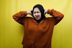 bela jovem asiática muçulmana com as mãos cobrindo os ouvidos, ruído, isolado foto