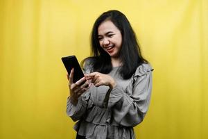 mulher jovem e bonita com as mãos segurando um smartphone, promovendo produto, apresentando algo, propaganda, isolado foto