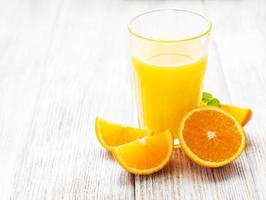 copo de suco e frutas de laranja foto