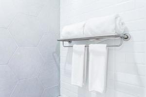 toalhas limpas com cabide no fundo interior do banheiro de parede. foto