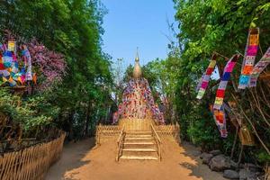 bandeiras de oração tung penduradas com guarda-chuva ou bandeira tradicional do norte penduradas em pagode de areia no templo phan tao para o festival Songkran é celebrado em um tradicional dia de ano novo em chiang mai, tailândia foto