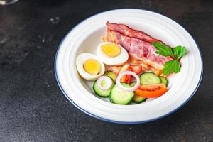 café da manhã inglês ovos, bacon, tomate, pepino, pão torrado foto
