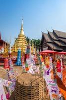 bandeiras de oração tung penduradas com guarda-chuva ou bandeira tradicional do norte penduradas em pagode de areia no templo phan tao para o festival Songkran é celebrado em um tradicional dia de ano novo em chiang mai, tailândia foto