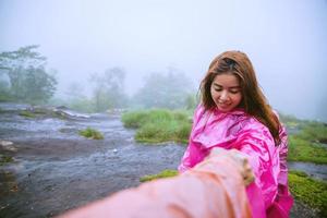 turista com capa de chuva rosa caminhando viagens aventura natureza na floresta tropical. viajar natureza, viajar relaxar, viajar na Tailândia, estação das chuvas. foto