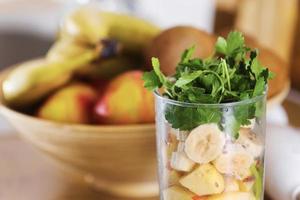 frutas esmagadas para smoothie. diferentes frutas tropicais e smoothie na mesa no fundo da cozinha em casa, conceito de estilo de vida de comer saudável. foco seletivo. foto