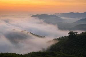 incrível névoa natural movendo-se sobre as montanhas naturais durante o nascer do sol pela manhã foto