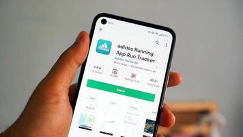 pekanbaru, indonésia 2021 - adidas em execução. app run tracker android app. o ícone do aplicativo na tela do celular de perto é segurado com a mão. foto