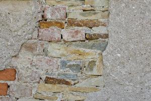 Parede de tijolo e pedra vintage antiga com textura de gesso branco quebrada foto