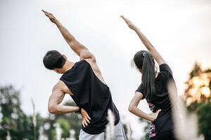 homens e mulheres se aquecem antes e depois do exercício. foto