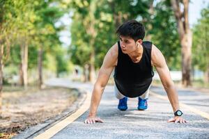 os homens usam camisas pretas com músculos flexionados na rua. foto