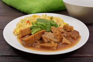 tempeh com molho de tomate e milho em uma mesa foto