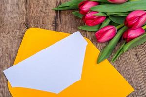 envelope rosa com tulipas em uma mesa foto