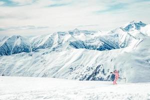 garota de terno rosa aproveite um passeio de snowboard foto