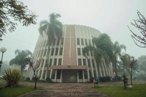 Bento Gonçalves, Brasil - 14 de julho de 2019. Igreja de São Bento em estilo moderno em meio a um jardim exuberante em um dia de neblina em Bento Gonçalves. uma simpática cidade do interior famosa por sua produção de vinho. foto