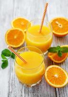 copos de suco e frutas de laranja
