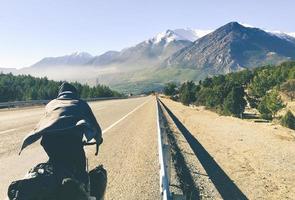 vista traseira close-up ciclista em ciclismo passeios de bicicleta em descida rápida ao ar livre em belas montanhas foto