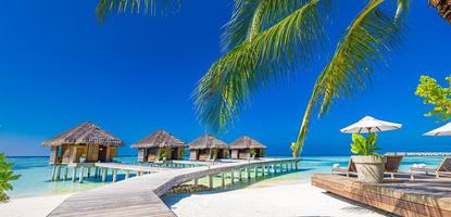 panorama incrível do pôr do sol nas maldivas. luxo resort vilas vista do mar com luzes LED suaves sob o céu colorido. lindo céu crepuscular e nuvens coloridas. fundo de praia lindo para férias de férias